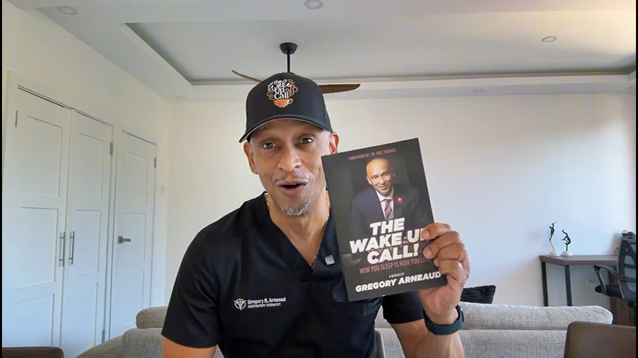 Gregory Arneaud holding his book The Wake Up Call!